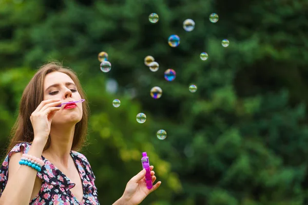幸福和无忧无虑的概念 开心的年轻女子在公园里吹肥皂泡泡室外 — 图库照片