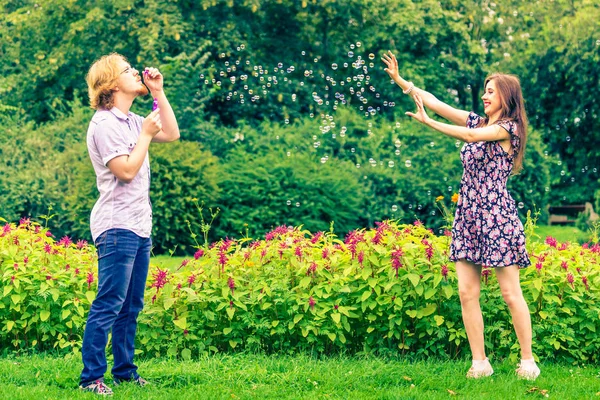 Feliz Divertido Hipster Pareja Jugando Juntos Soplando Jabón Burbujas Aire — Foto de Stock