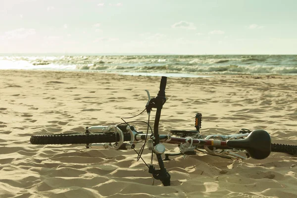 日没の天候の間に砂浜のビーチで横になっている自転車 夏のスポーツ 旅行の概念 — ストック写真