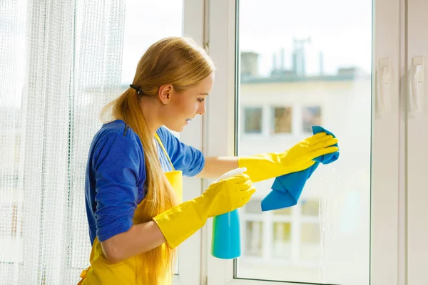 青いラグとスプレー洗剤で黄色の手袋のクリーニングウィンドウの若い女性 春の掃除 家事のコンセプト — ストック写真