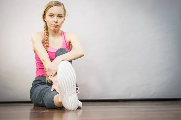 年轻的金发女人 坐在木地板室内准备练习的运动服 在家里 培训健康和健康 — 图库照片