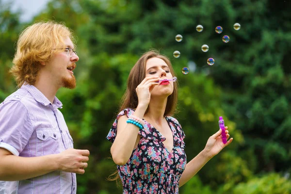 Счастье Беззаботная Концепция Молодая Женщина Мужчина Веселятся Выдувая Мыльные Пузыри — стоковое фото