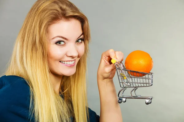 购买健康食品 素食产品 女人抱着购物车里面的橙 — 图库照片