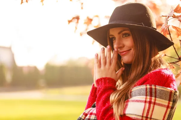 秋の公園を歩いて魅力的な若い女性 赤いセーター マフラーと黒い帽子を身に着けているファッショナブルな女の子 — ストック写真