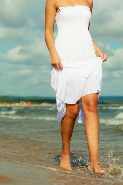 魅力的なブロンド女性身に着けています長い白いロマンチックなドレスウォーキングで水の海で夏 — ストック写真