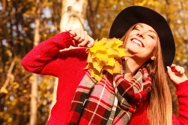 紅葉公園でリラックスした女性 Feshionable 女性スタイリッシュな黒い帽子の黄色のカエデを保持している葉を手に 日光を楽しんで — ストック写真