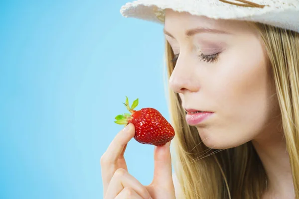 年轻的妇女闭上眼睛闻到新鲜的草莓水果在蓝色 健康膳食 — 图库照片