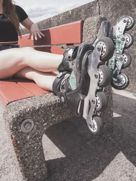 Woman Wearing Roller Skates Sitting Bench Raised Legs Bizarre Angle — Stock Photo, Image