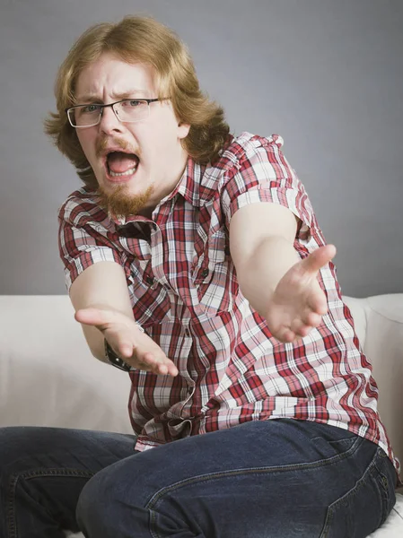 Nerd Cercando Uomo Seduto Sul Divano Guardando Fotocamera Lamentandosi Qualcosa — Foto Stock