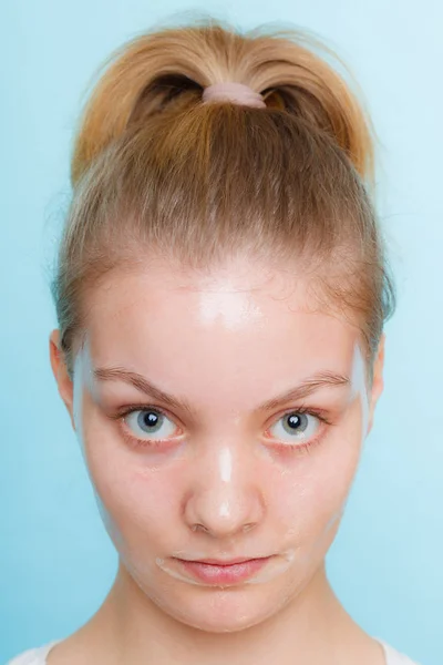 マスクを顔の皮の若い女性 美容と肌ケア 青の背景に撮影スタジオ — ストック写真
