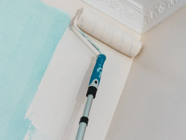 ローラーブラシを使って壁に塗料を塗る人 住宅改修のコンセプト — ストック写真