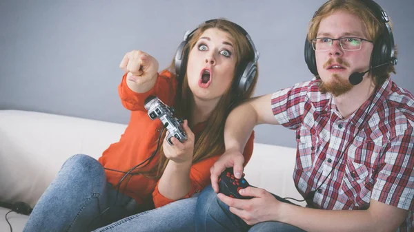 カップルが一緒にビデオゲームをプレイすることによって余暇時間を楽しんで 男と女はゲームによって感情的である ロイヤリティフリーのストック写真