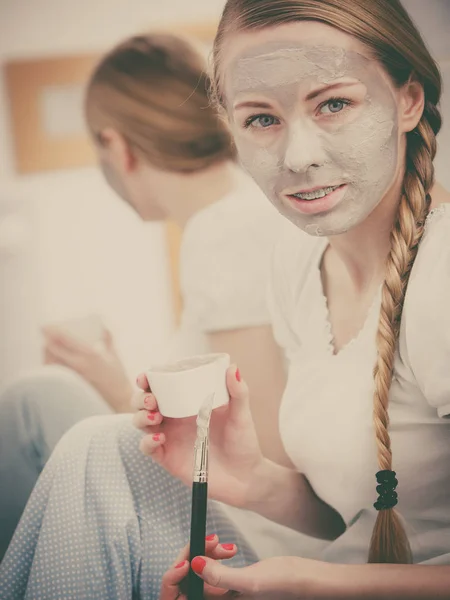 スキンケアだ 顔に灰色の粘土泥マスクを持つバスルームでブロンドの女性 若い女性が肌の世話をしている スパの美のウェルネス フィルタリングされた写真 — ストック写真