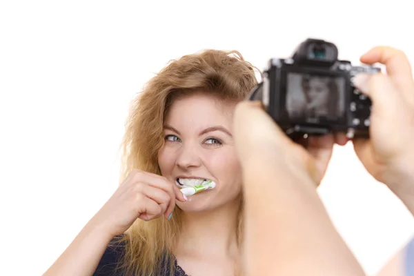 快乐积极的女人刷她的牙齿 人摄影者把她的照片 工作室拍摄 — 图库照片