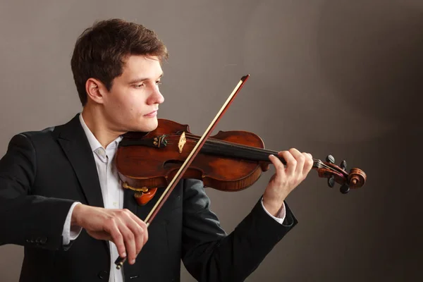 音楽への情熱 趣味概念 若い男は エレガントな木製のバイオリン演奏を着ています 暗い背景で撮影スタジオ — ストック写真