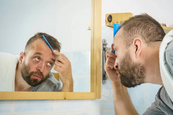 Dospělý Muž Stojící Před Zrcadlem Koupelně Kartáčuje Krátké Vlasy Hřebenem — Stock fotografie