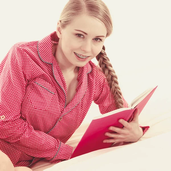 Девочка Лежит Постели Читает Книгу Молодая Блондинка Красной Пижаме Расслабляется — стоковое фото