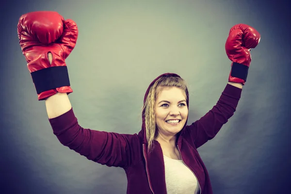 赤のボクシンググローブを身に着けているスポーティ女性は 戦いに勝つ 安心感と幸福感動機付けされています 暗い背景で撮影したスタジオ — ストック写真