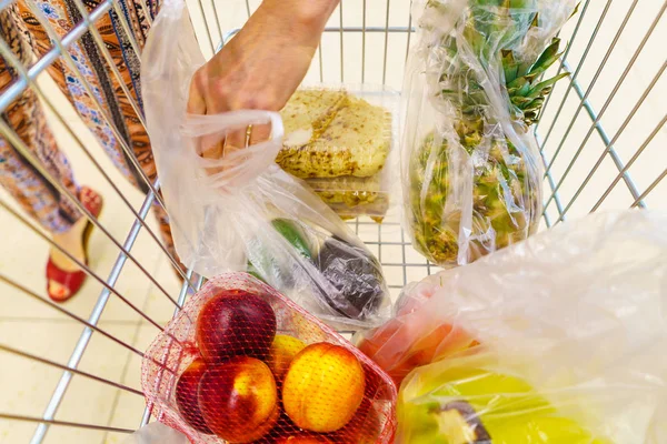 スーパーマーケットセルフサービスの食料品店でショッピングカートトロリーを持つ女性の顧客 果物や野菜が入っている 小売業 — ストック写真