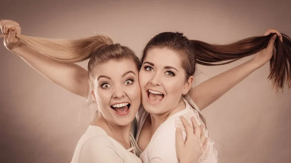 Две Счастливые Подруги Обнимаются Улыбаются Радости Держат Волосы Женская Дружба — стоковое фото