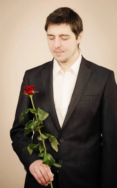 Elegant young man with red rose. — Stock Photo, Image