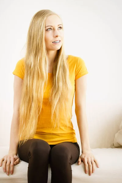 Счастливая Молодая Женщина Длинными Светлыми Волосами Сидит Диване Думает — стоковое фото