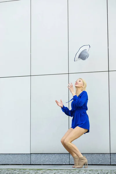 青いジャンプスーツを着た幸せな女性が太陽の帽子を投げるのを楽しんでいます ファッションモデルと夏服 — ストック写真