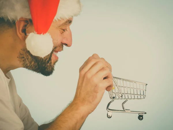 Mann Mit Weihnachtsmannmütze Und Leerem Einkaufswagen Getöntes Bild Weihnachten Saisonverkauf — Stockfoto