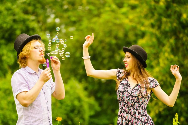 Šťastný Legrační Hipster Pár Hrát Spolu Foukání Mýdlo Bubliny Venku — Stock fotografie