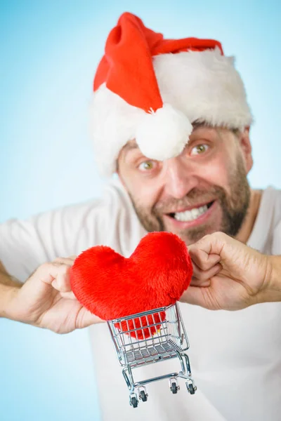 戴着圣诞老人的男人拿着红色心脏的购物篮 圣诞节 慈善分享概念 — 图库照片