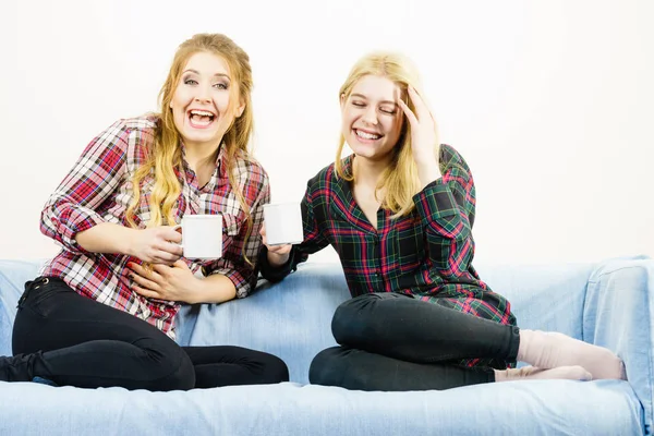 Duas Amigas Sentadas Juntas Sofá Conversando Bebendo Chá Café Divertindo — Fotografia de Stock