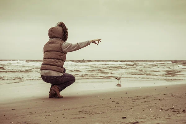 リラクゼーションとレジャー 海岸を歩く女 自然界の水の場所の近くに指で女性の観光客を指す 秋の寒い季節 — ストック写真
