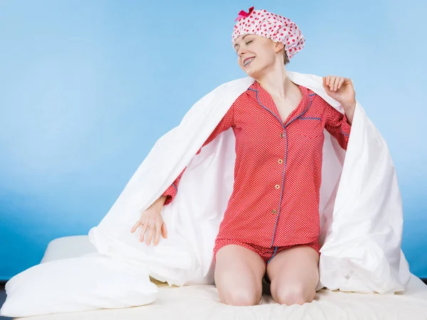 白い新鮮な毛布で覆われたピンクのパジャマ ベッドの上に座っている点線の水泳帽を身に着けているシャワーの後面白い幸せな女 — ストック写真