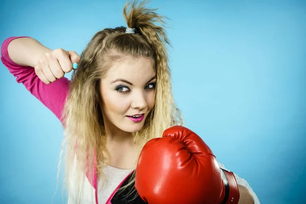 滑稽的金发碧眼的女拳击手 戴着大大的有趣的红色手套 打着拳击工作室的蓝色镜头 — 图库照片