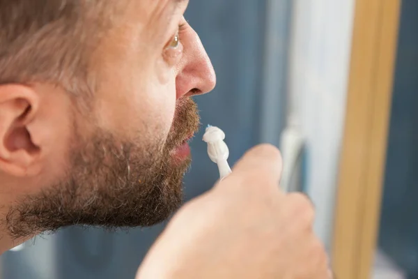 Erwachsener Mann Beim Morgendlichen Zähneputzen Mit Blick Auf Den Badezimmerspiegel — Stockfoto