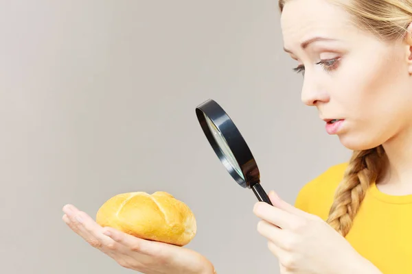 Chockad Kvinna Håller Bröd Rulle Och Förstoringsglas Undersöka Vete Produkt — Stockfoto