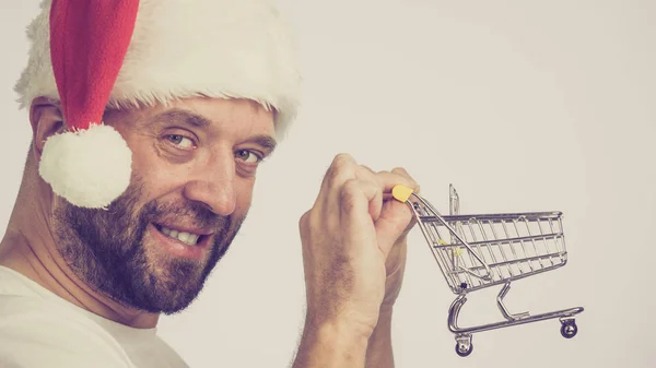 Mann Mit Weihnachtsmannmütze Und Leerem Einkaufswagen Getöntes Bild Weihnachten Saisonverkauf — Stockfoto