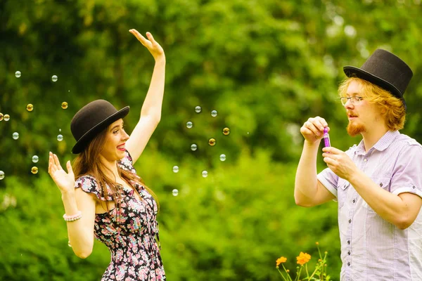 Feliz Divertido Hipster Pareja Jugando Juntos Soplando Jabón Burbujas Aire — Foto de Stock