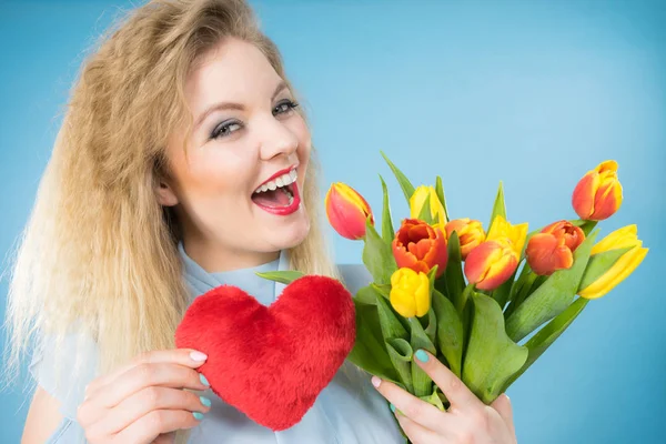 国际妇女日或情人节 迷人而快乐的金发碧眼的女人 把郁金香束和红心的标志化作一种时尚 蓝色的 — 图库照片
