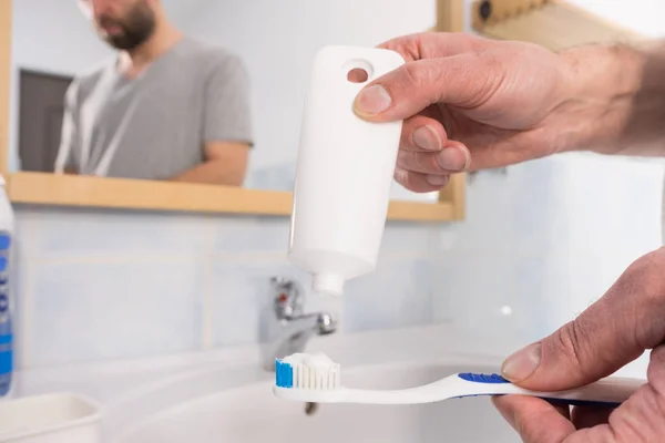 歯ブラシに歯磨き粉をかける人 歯の衛生管理 きれいな口腔ブラシの基本概念 — ストック写真