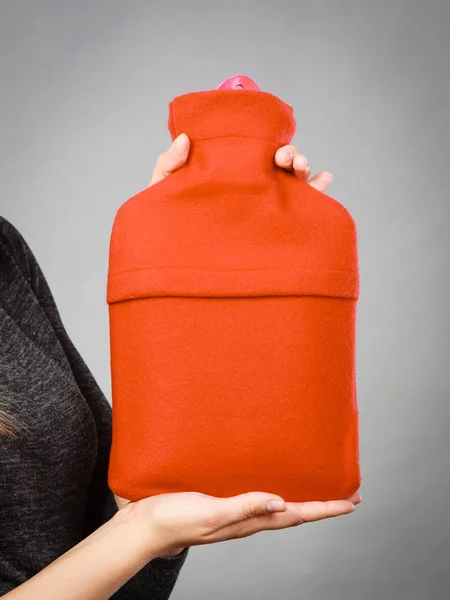グレーに赤の柔らかいフリース カバーの手に暖かいお湯をボトルを保持している女性 ヘルスケア 治療オブジェクト概念 — ストック写真