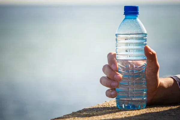 Męskiej Ręki Trzymającej Butelki Wodą Odkryty Brzegu Morza — Zdjęcie stockowe