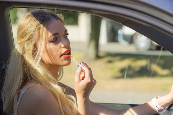 뒷모습을 매력적 여자가 운전하면서 립스틱 립글로스를 바르는 — 스톡 사진