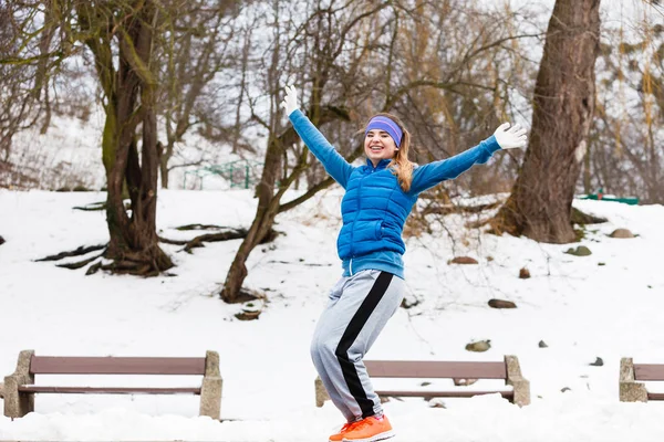 户外运动 运动服创意 冬天穿着保暖运动服的女人在外面锻炼 高兴得跳了起来 — 图库照片