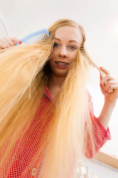 女人们穿着睡衣在浴室里玩乐 一边梳理着她长长的金发 风吹着的头发 从底部被射中 — 图库照片
