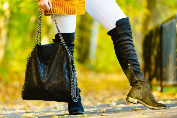 大きなハンドバッグを保持黒スエード高膝黒ブーツを提示女性 秋のファッション 秋のシーズンスタイルの衣装 公園を散歩している女性 — ストック写真