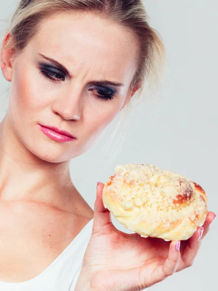 饮食的困境 成长从吃糖果概念的脂肪 悲伤未定的女人抱着蛋糕甜包子在手 试图抵制诱惑 — 图库照片