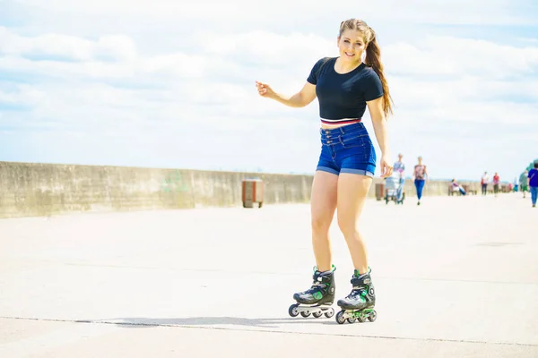 長い乗車後にリラックスローラースケートを身に着けている幸せな若い女性 女性は桟橋で夏の時間の間に楽しみを持っているスポーティ — ストック写真
