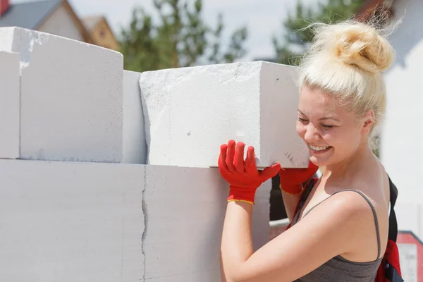 强壮漂亮的女人在建筑工地工作 建造房屋 安装灰色气砖 工业工作概念 — 图库照片