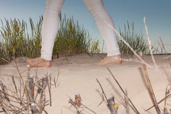 認識できない女性が中に砂のビーチの砂丘の上を歩きます 唯一の足のショット — ストック写真